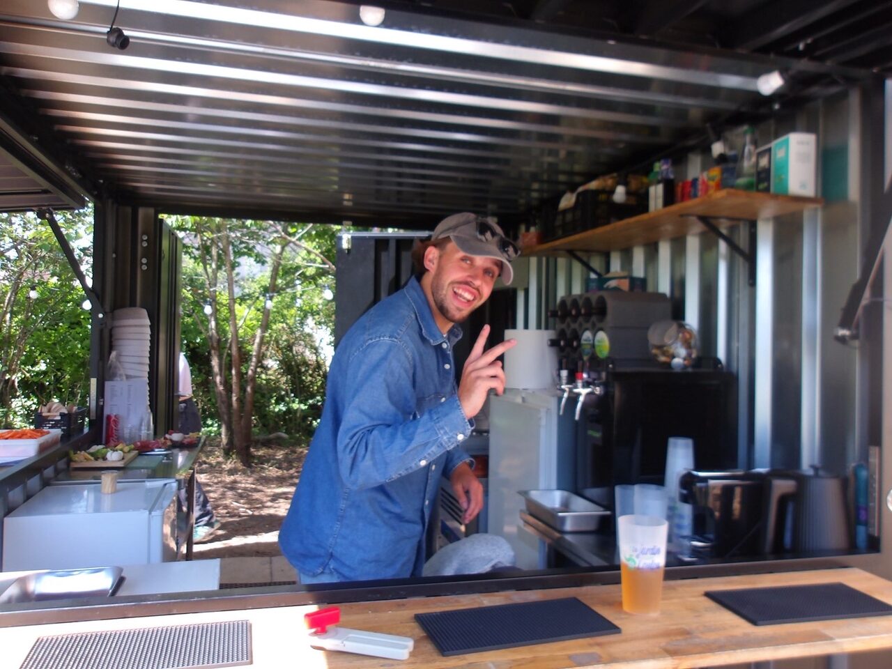 Le barman du Jardin de Loulou dans le bar-container, tireuses à bière