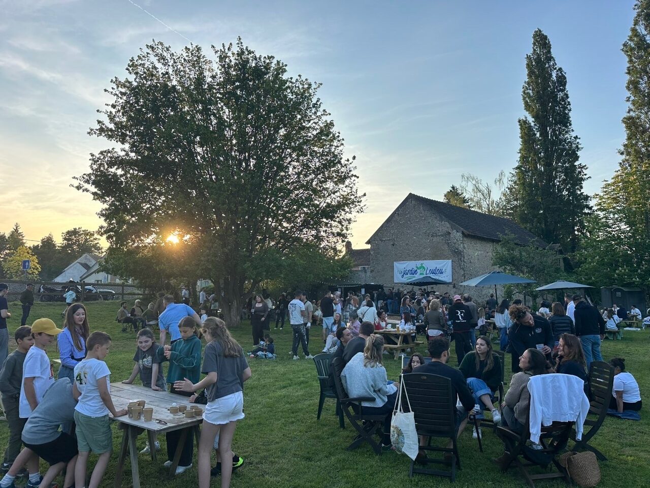 Tablée animée au crépuscule devant la grange du Jardin de Loulou