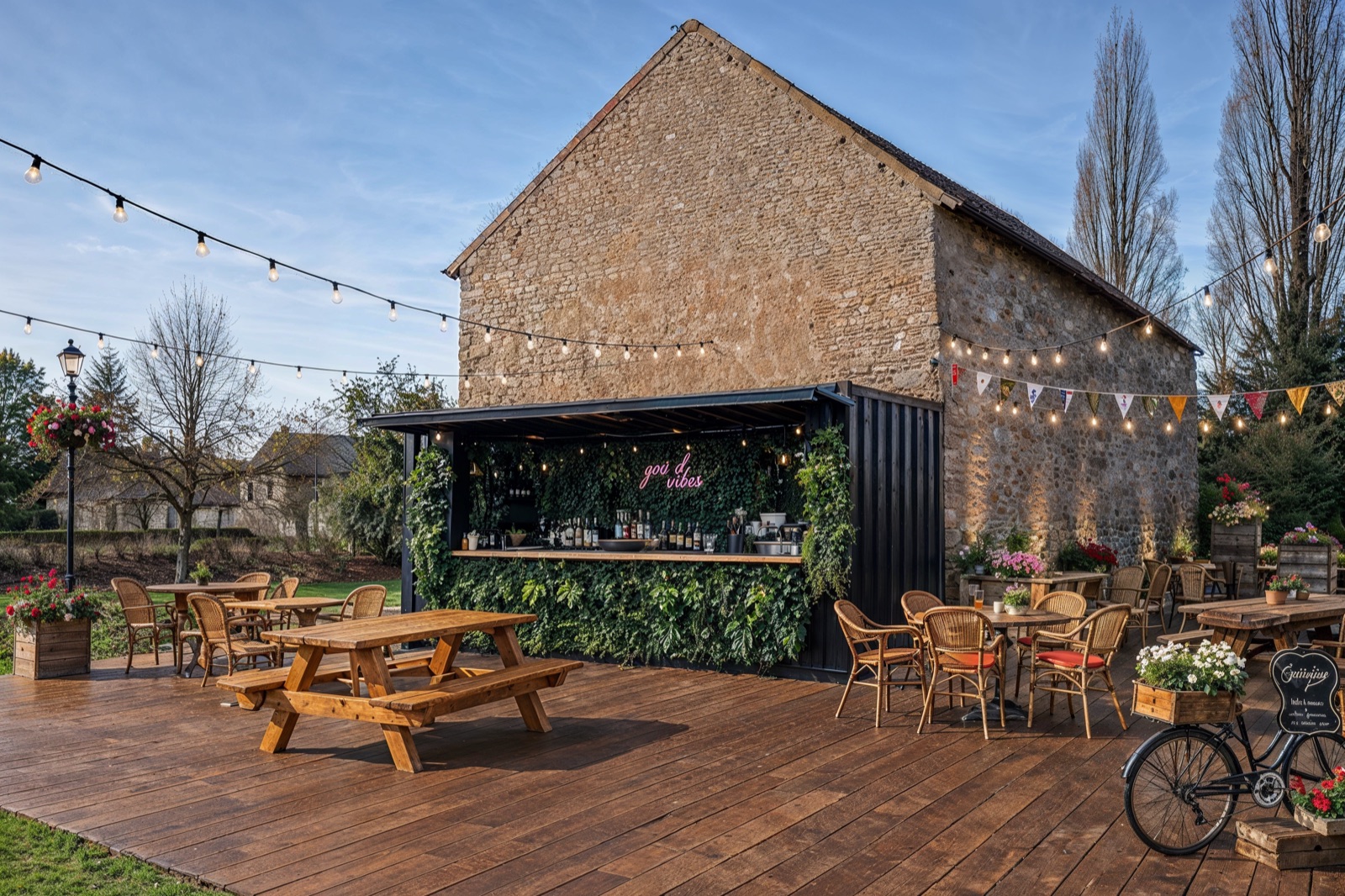 Terrasse du Jardin de Loulou avec guirlandes lumineuses, bar et tables en bois